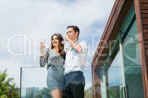 Young couple drinking champagne at balcony
