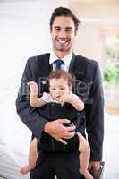 Portrait of smiling father carrying baby