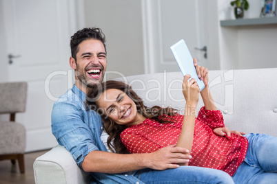Portrait of cheerful couple with digital tablet