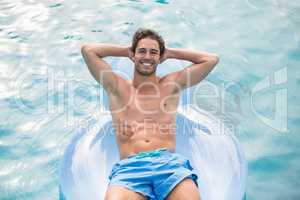Handsome man relaxing on inflatable ring