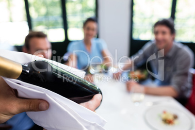 Close-up of waiter carrying a wine bottle