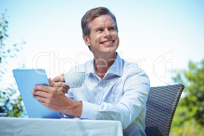 Businessman using tablet with coffee