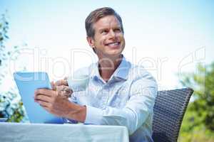 Businessman using tablet with coffee