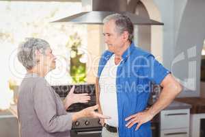 Side view of senior couple arguing in kitchen