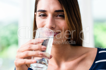 Portrait of smiling young woman drinking water
