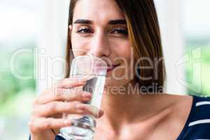 Portrait of smiling young woman drinking water