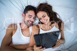 High angle view of smiling couple using digital tablet