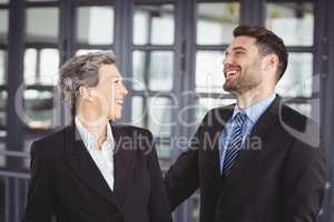 Business people laughing while standing in office