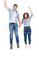 Excited young couple holding hands and jumping