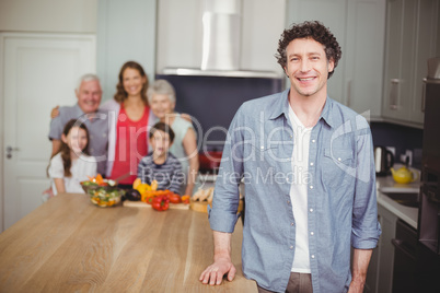 Portrait of happy young man with family in kitchen