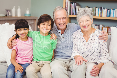 Portrait of happy grandchildren with grandparents at home