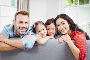 Happy family leaning on sofa at home