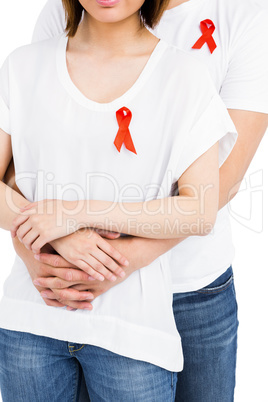 Midsection of man and woman with red ribbon