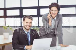 Business people with mobile phone and laptop in office