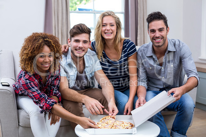 Portrait of multi-ethnic friends enjoying pizza at home