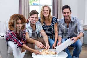 Portrait of multi-ethnic friends enjoying pizza at home