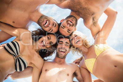 Group of friends standing in circle and smiling at camera