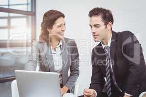Happy business people using laptop