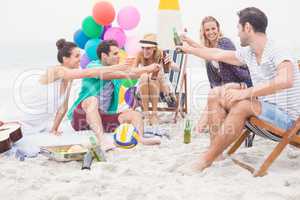 Group of friends toasting beer bottles on the beach