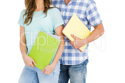 Mid section of young couple holding book and folder
