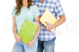 Mid section of young couple holding book and folder