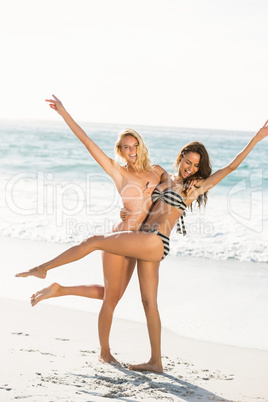 Beautiful excited friends posing on the beach