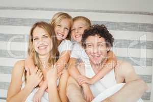 Portrait of happy family on bed