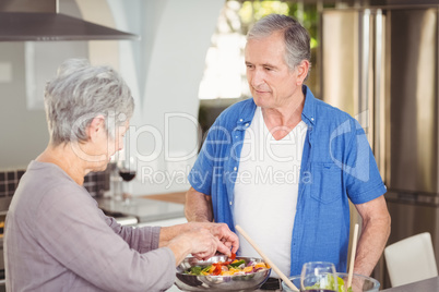 Active senior couple preparing salad