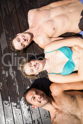 Smiling friends relaxing on wooden deck