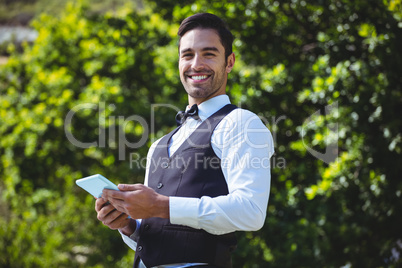 Handsome waiter using tablet computer