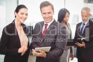 Portrait of businesswoman and businessman with digital tablet