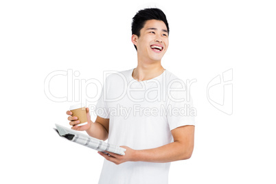 Young man having coffee and reading newspaper