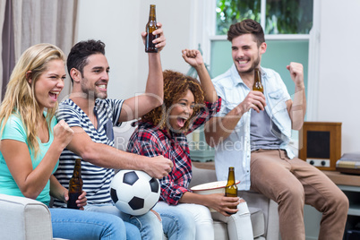 Multi-ethnic friends with beer bottle enjoying soccer match