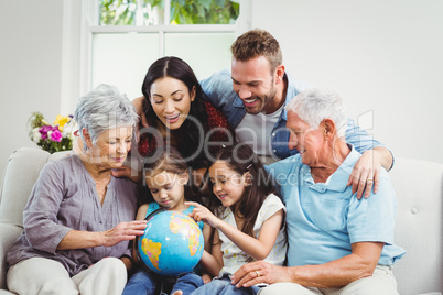 Family on sofa looking at terrestrial globe