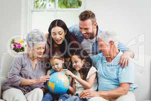 Family on sofa looking at terrestrial globe