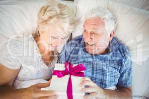 High angle view of senior man giving wife gift