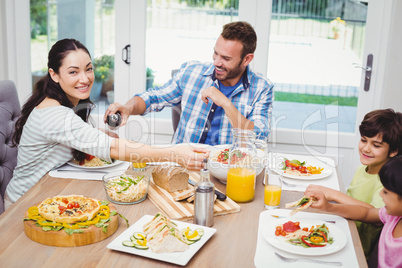 Happy family having food while sitting at dining table
