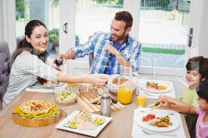 Happy family having food while sitting at dining table