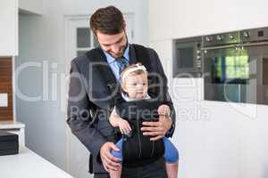 Businessman carrying daughter at home