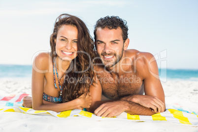Couple lying on a towel at the beach