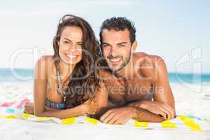 Couple lying on a towel at the beach
