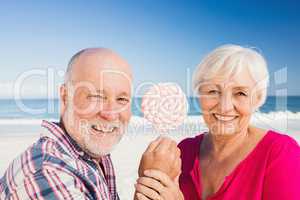 Senior couple holding lollipop