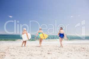 Senior woman friends holding surfboard