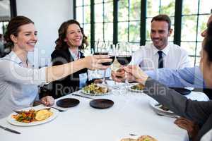 Group of businesspeople toasting wine glass during business lunc