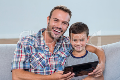 Father and son using digital tablet