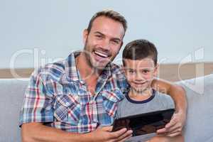 Father and son using digital tablet