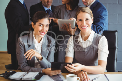 Businesswomen using digital tablet in conference room