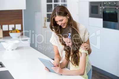 Mother and daughter using digital tablet