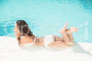 Beautiful woman lying by swimming pool