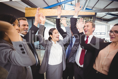 Cheerful businesspeople raising hands